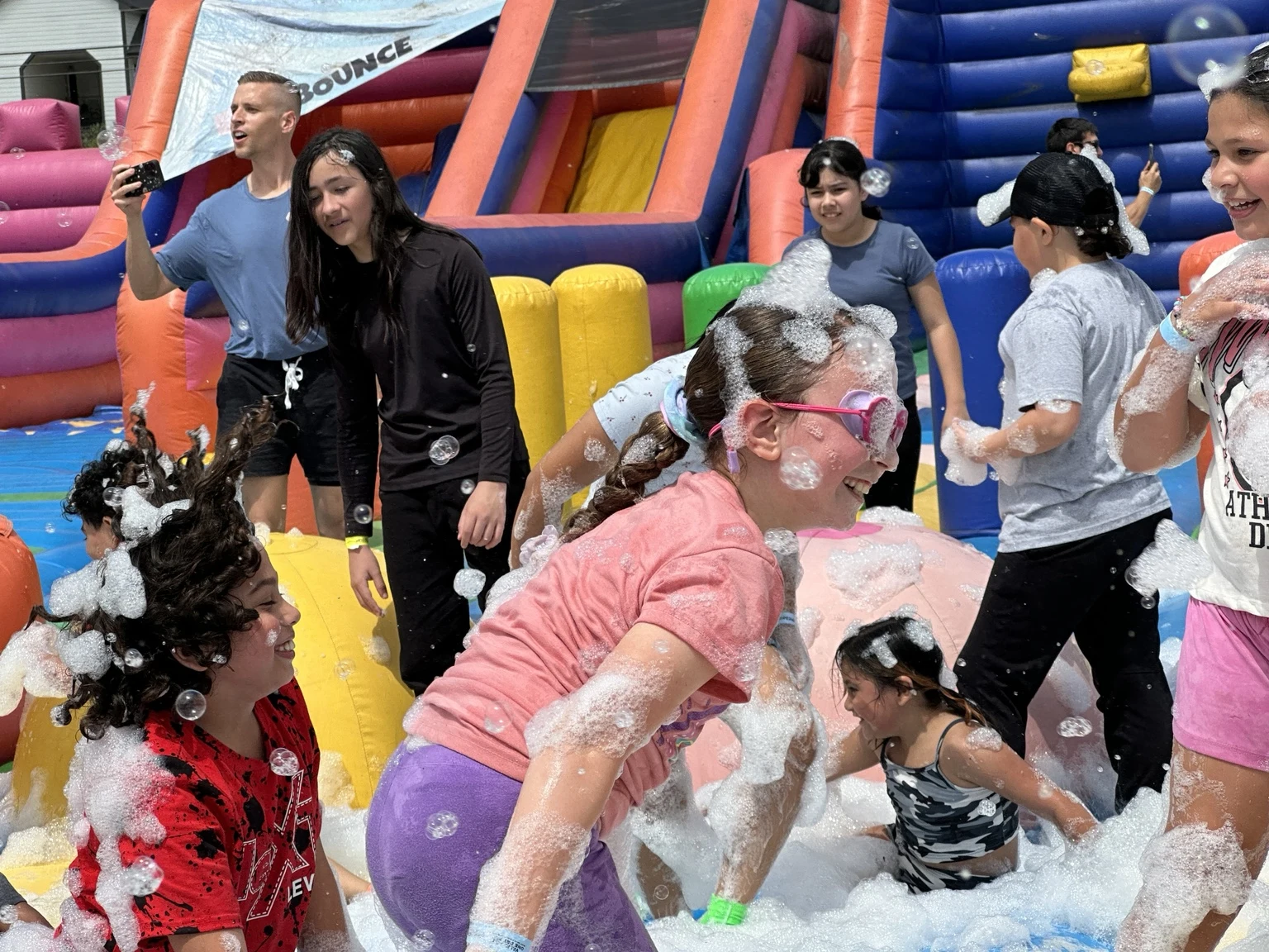 Families laughing and playing in foam