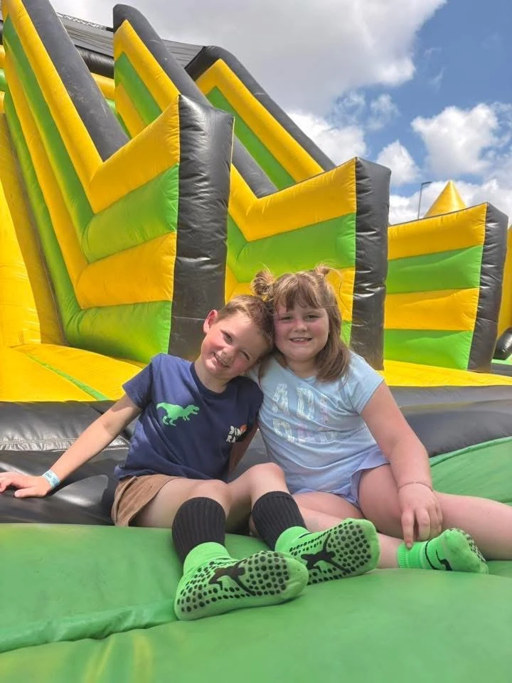Two friends smiling on an inflatable slide